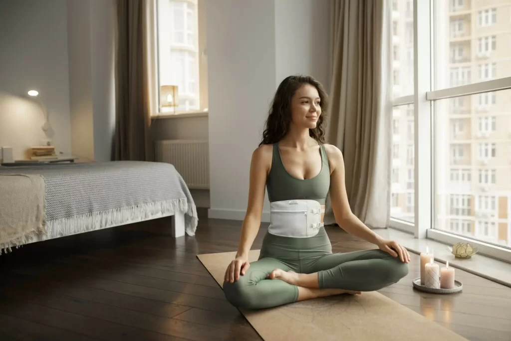 A woman wears a castor oil pack and relaxes in her bedroom